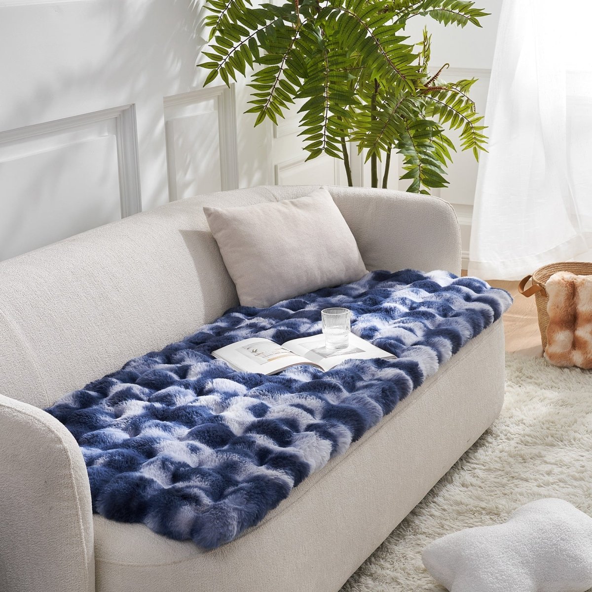 Tie-dye blue couch cover on a beige sofa with a plant in the background#color_Tie-dye Blue