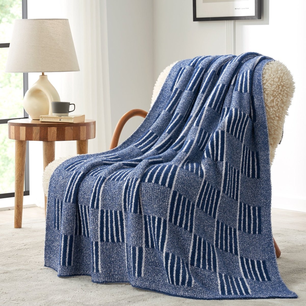 Reversible Heather Checkered Feather Yarn Throw Blanket in Navy Blue draped over an armchair, showcasing its soft texture and modern checkered pattern design. #color_Navy Blue