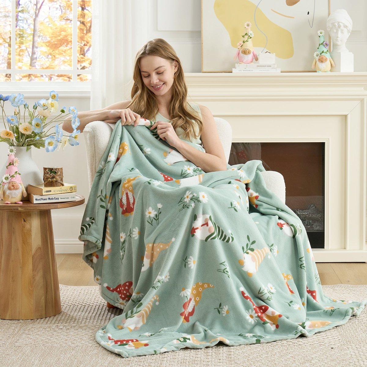 Woman relaxing on a chair with a spring gnomes milkyplush throw blanket in Green, enjoying soft and cozy comfort #color_Sage Green