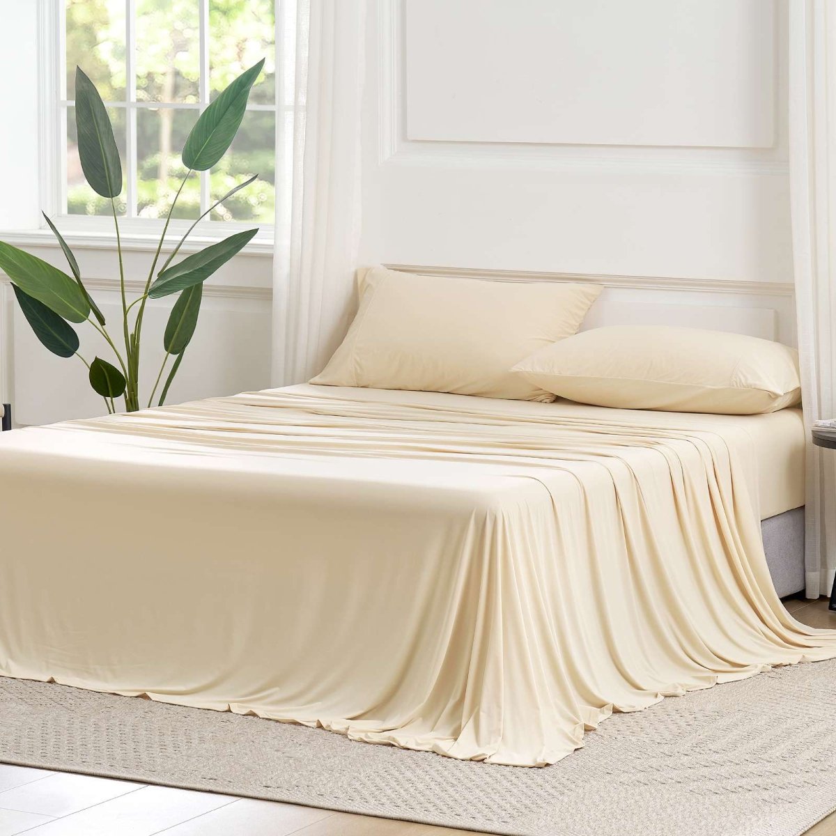 Cozy Bliss Outlast® Performance Cooling Sheet Set draped across a bed in a bright bedroom, showcasing the complete bedding appearance. #color_Beige