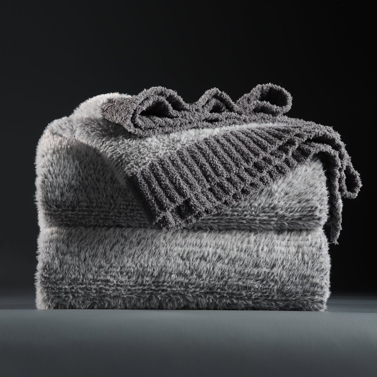 Faux Mink Feather Knit Throw Blanket in Grey neatly folded stack, showcasing soft feather yarn and premium texture. #color_Grey