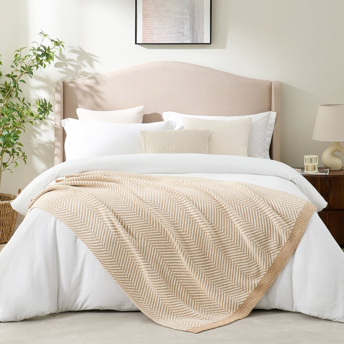 Reversible herringbone feather yarn knit throw blanket styled across a modern white bed #color_Beige
