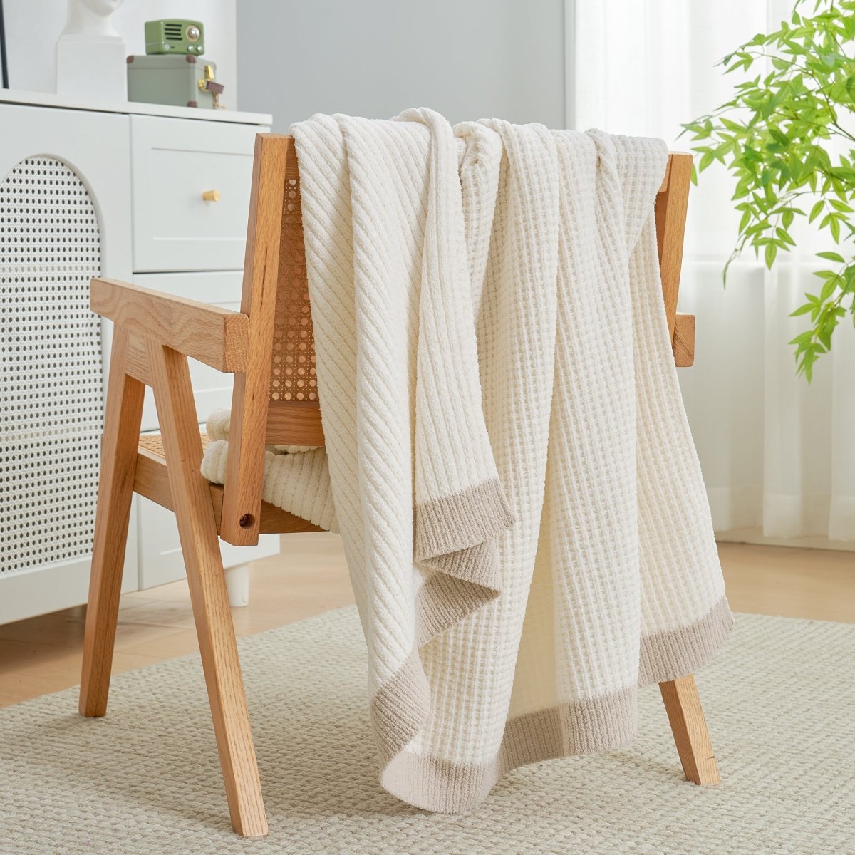 Chenille Waffle Knit Throw Blanket in Ivory draped over an armchair, creating a warm, inviting and stylish home atmosphere. #color_Ivory