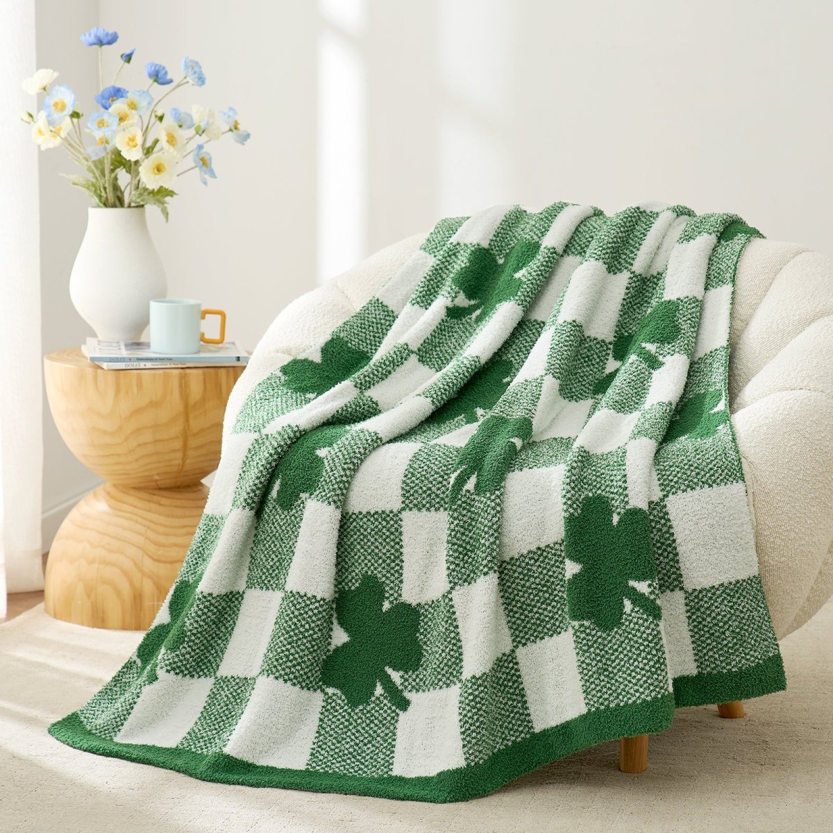 Green and white checkered blanket with shamrock pattern draped over a sofa in a cozy living room. #color_Xmas Green