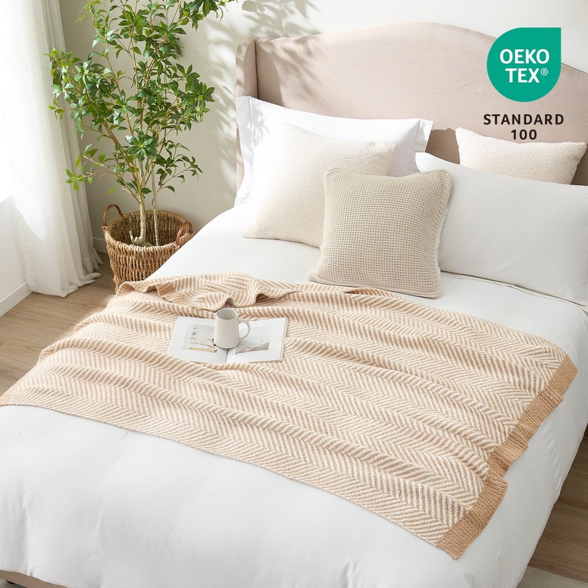 OEKO-TEX STANDARD 100 certified herringbone knit throw blanket styled on a white bed #color_Beige