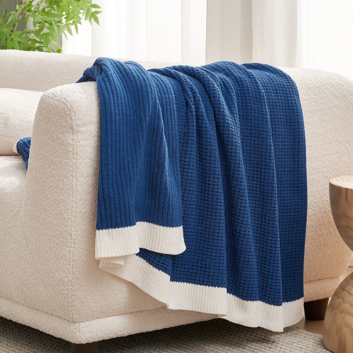 Chenille Waffle Knit Throw Blanket in Dark Blue draped over a sofa, creating a cozy feel. #color_Dark Blue