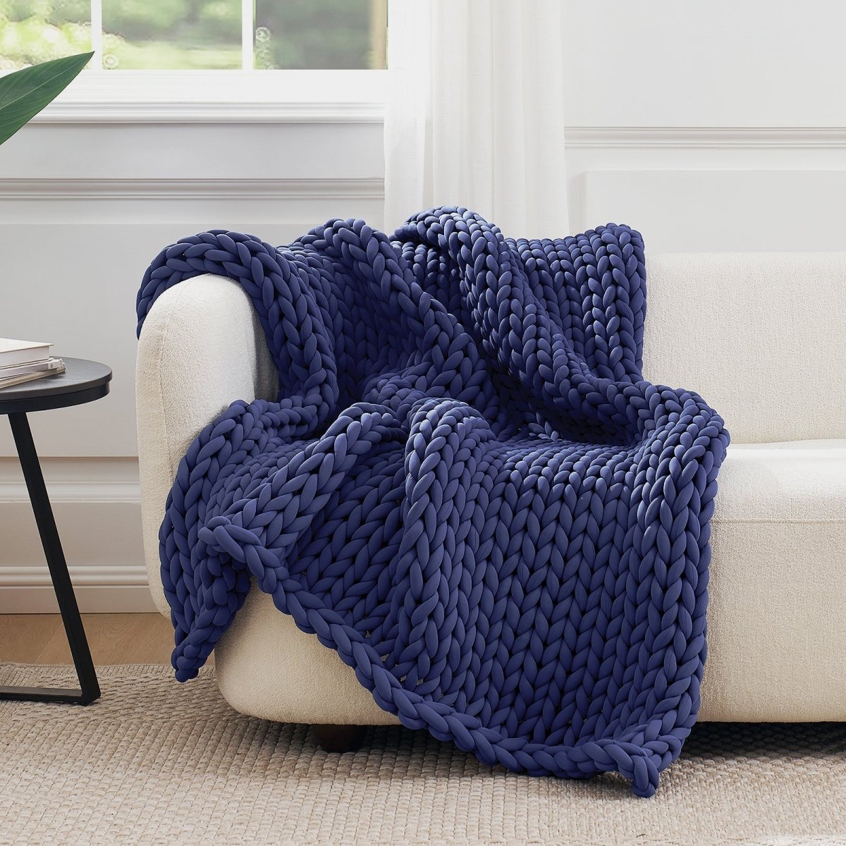Cozy Bliss Performance Cooling Weighted Blanket chunky knit blanket draped on sofa #color_Mottled Navy Blue