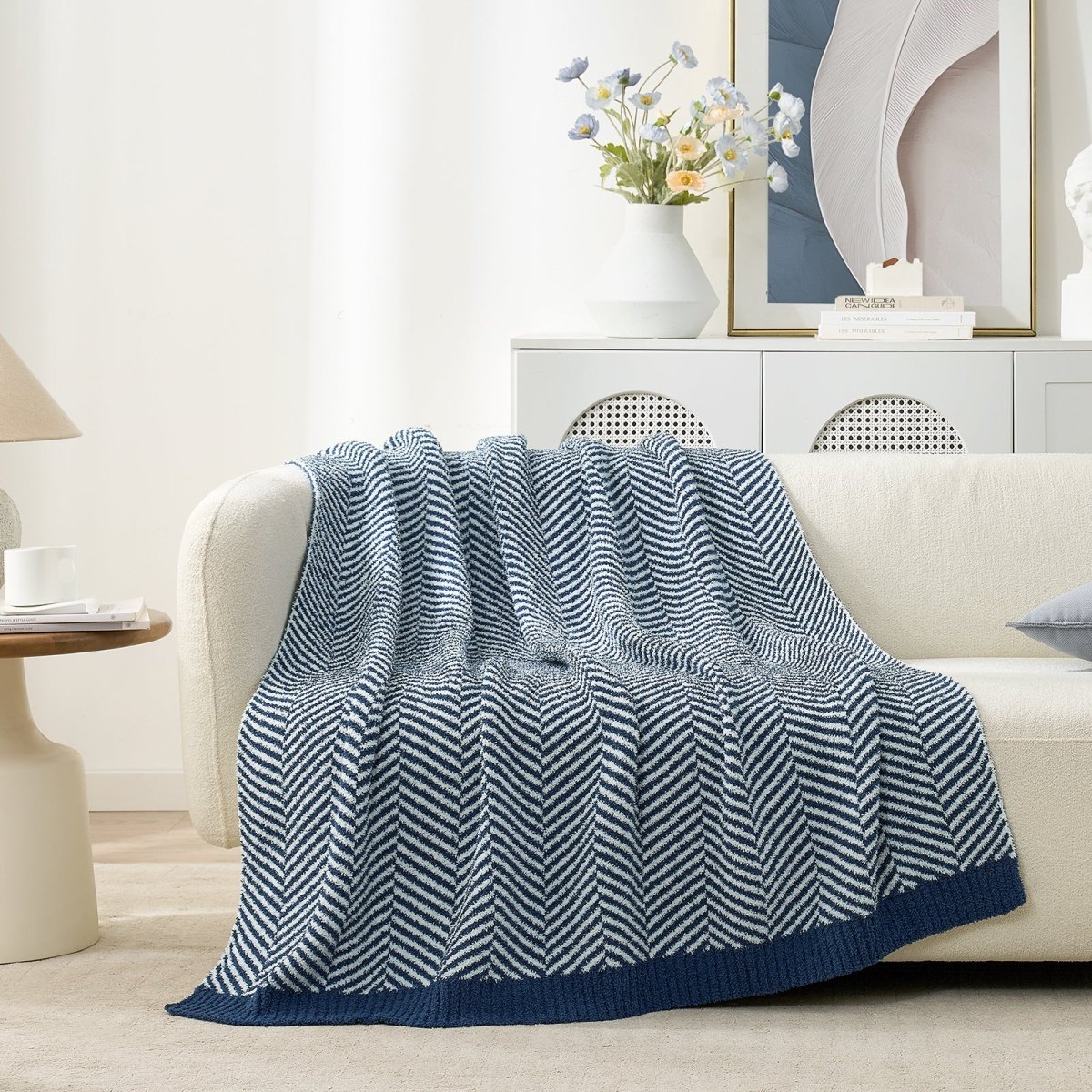 Cozy Bliss reversible knit throw blanket draped elegantly over a cream sofa #color_Navy Blue