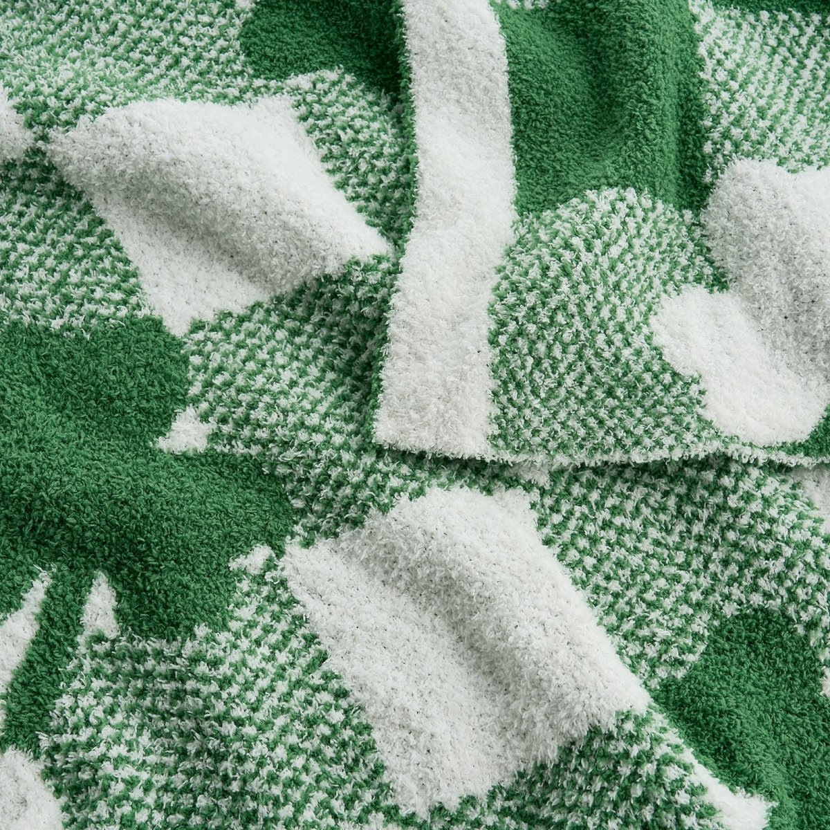 Close-up of a green and white patterned fabric with leaf designs. #color_Xmas Green