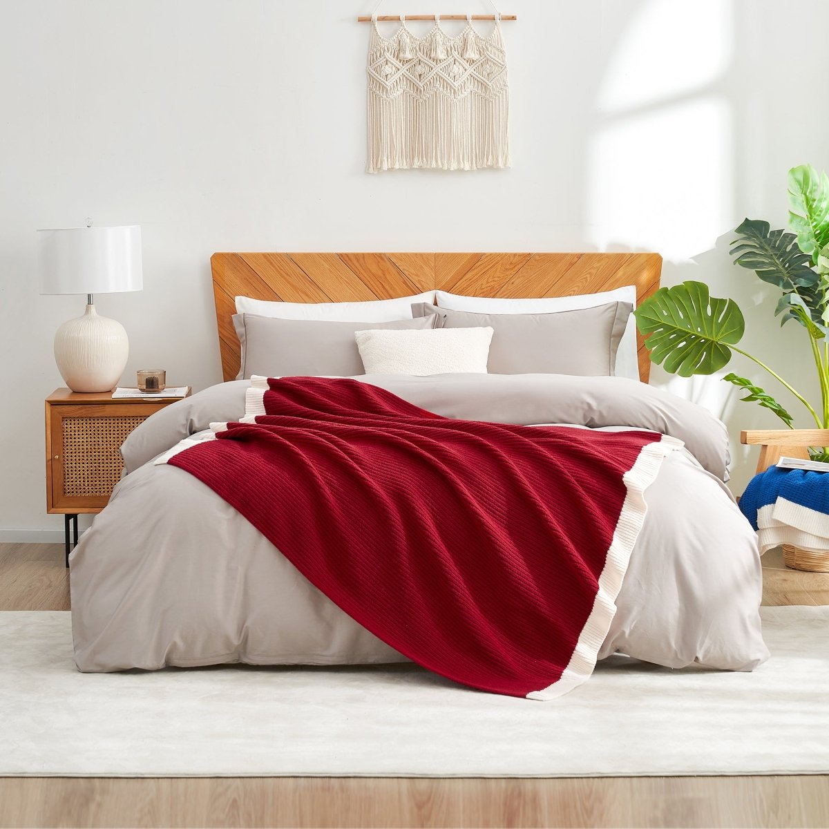 Bedroom with a wooden bed, red blanket, and white pillows. #color_Christmas Red