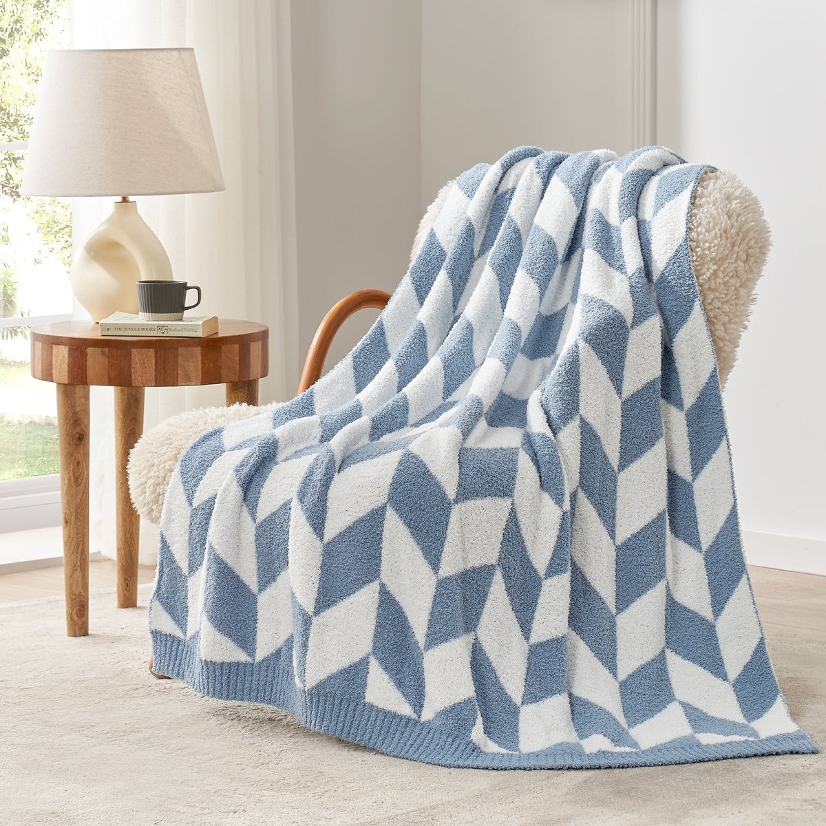 Chevron Feather Yarn Knit Throw Blanket in Blue draped over an armchair, showcasing soft feather yarn texture and chevron pattern design. #color_Misty Blue