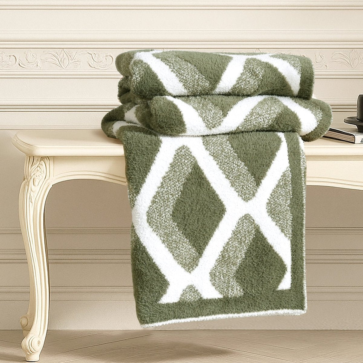 Diamond Feather Yarn Throw Blanket in Green neatly folded on a table, showcasing plush texture and detailed diamond knit design. #color_Oliver Green