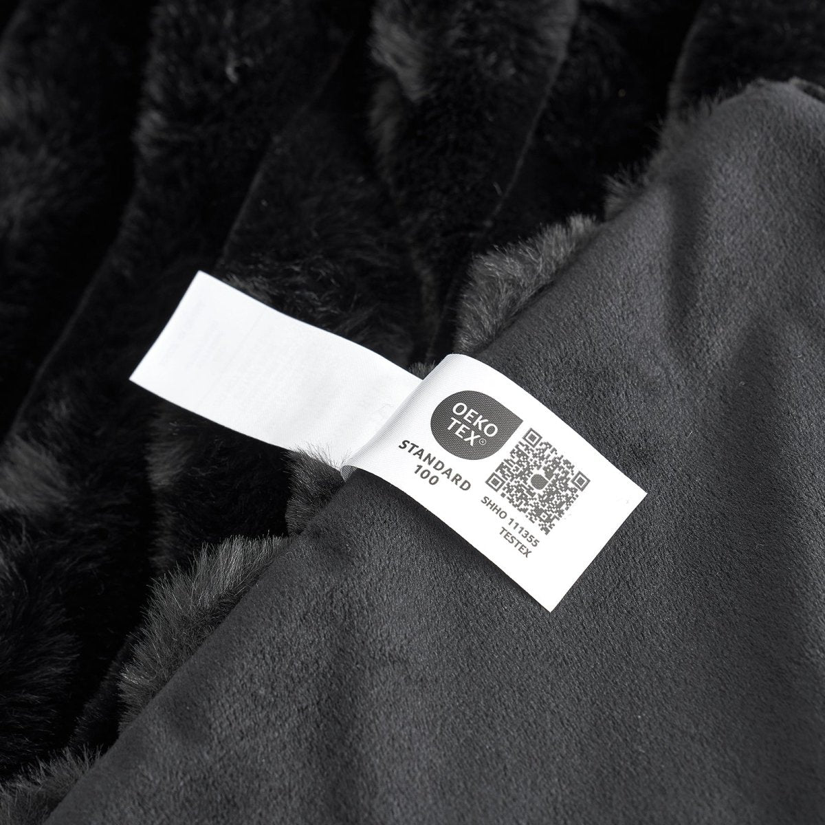 Close-up of OEKO-TEX Certified label of Black Faux Fur Blanket #color_Black