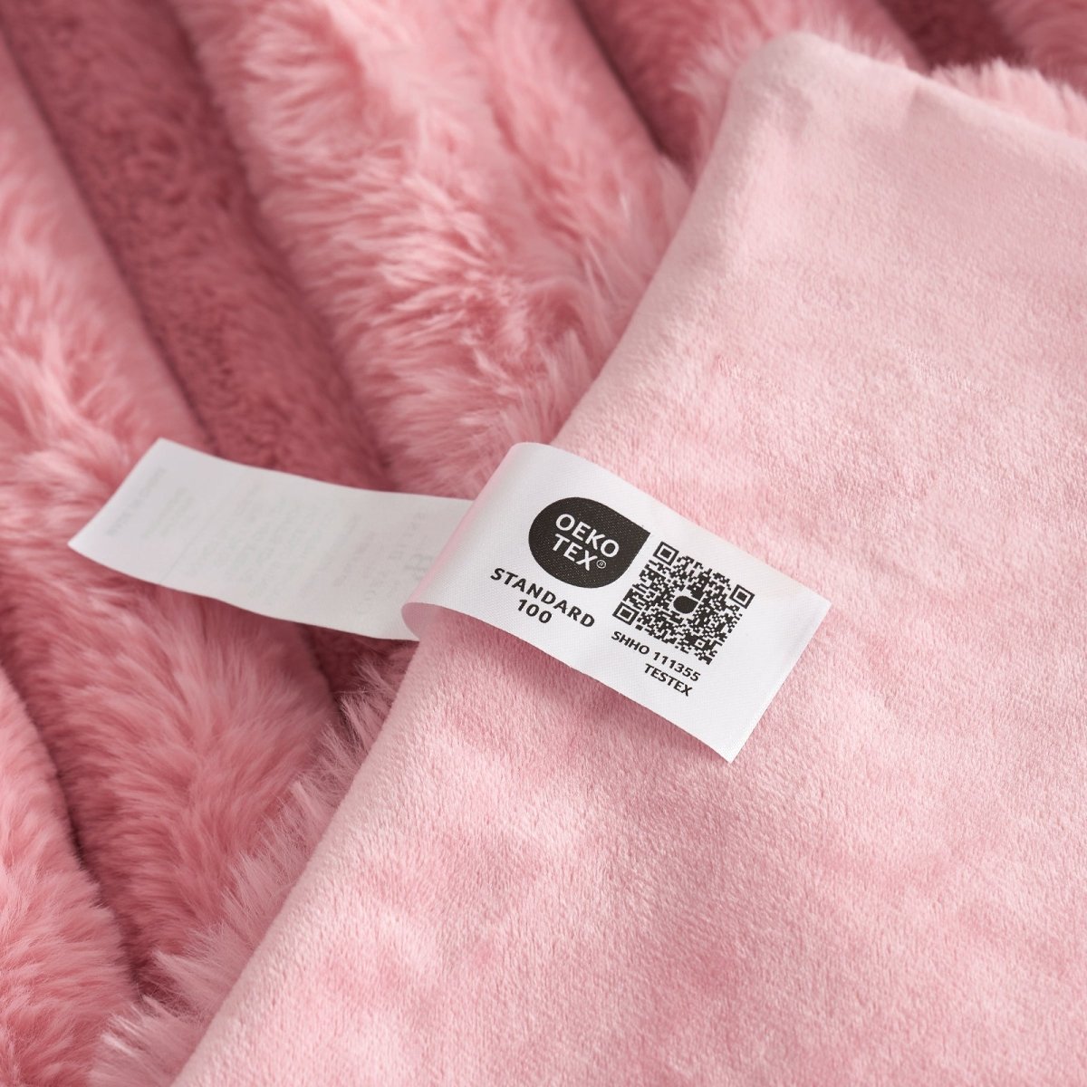 Close-up of Cozy Bliss pink faux fur blanket with Oeko-Tex Standard 100 label, soft and cozy bedding #color_Hot Pink