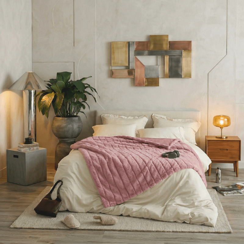 Cozy Bliss sheared faux fur throw blanket layered across the bed in a blush pink room display #color_Pink