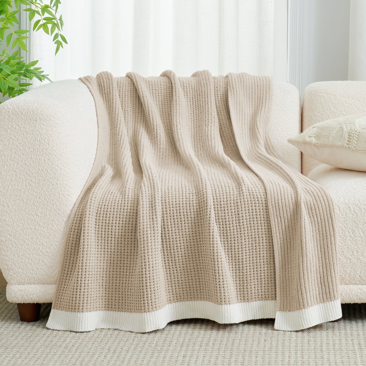 Chenille Waffle Knit Throw Blanket in Beige draped over a sofa, showcasing its soft neutral tone and texture. #color_Beige
