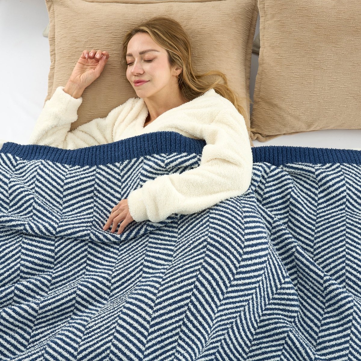 Woman sleeping comfortably under the Cozy Bliss feather yarn knit throw blanket #color_Navy Blue