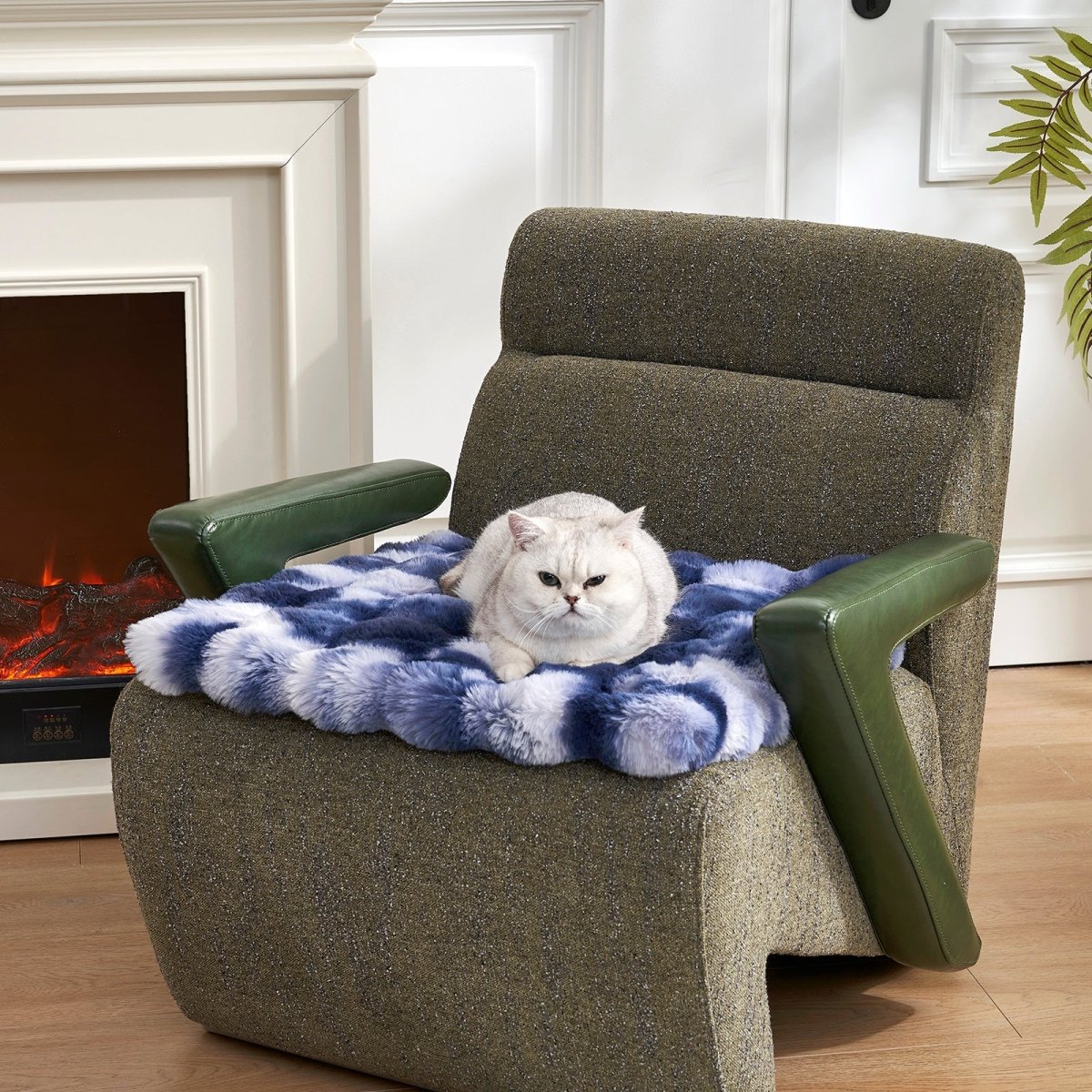 Cat sitting on a tie-dye blue fluffy couch cover on a brown armchair in a cozy living room.#color_Tie-dye Blue