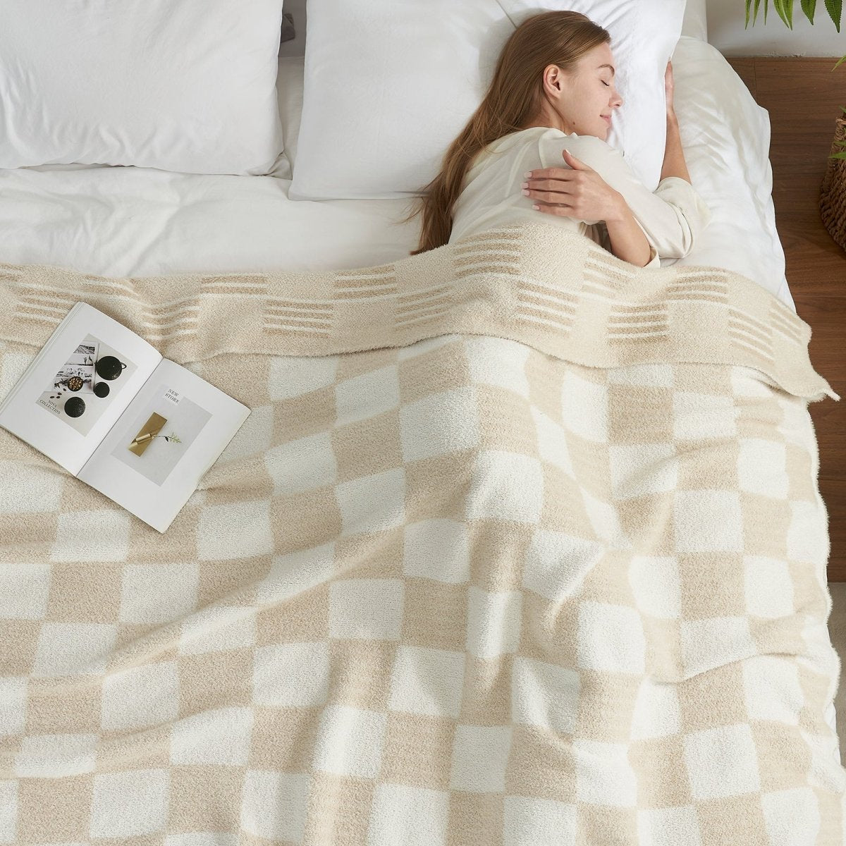 Woman resting in bed under a Reversible Heather Checkered Feather Yarn Throw Blanket in Cream White, ideal for relaxation and comfort. #color_Cream White