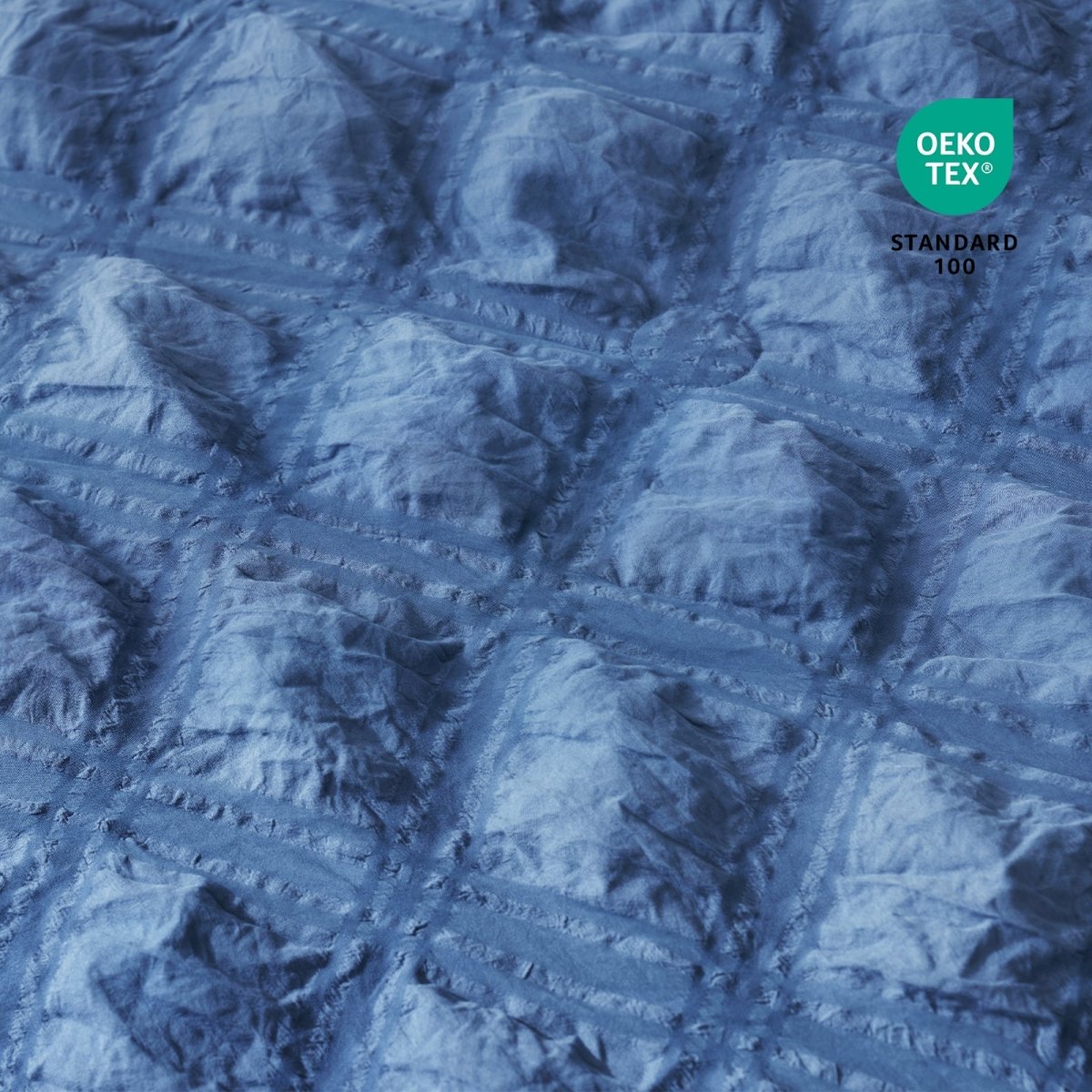 Close-up of Cozy Bliss Textured blue fabric with OEKO-TEX Standard 100 certification.#color_Dark Blue