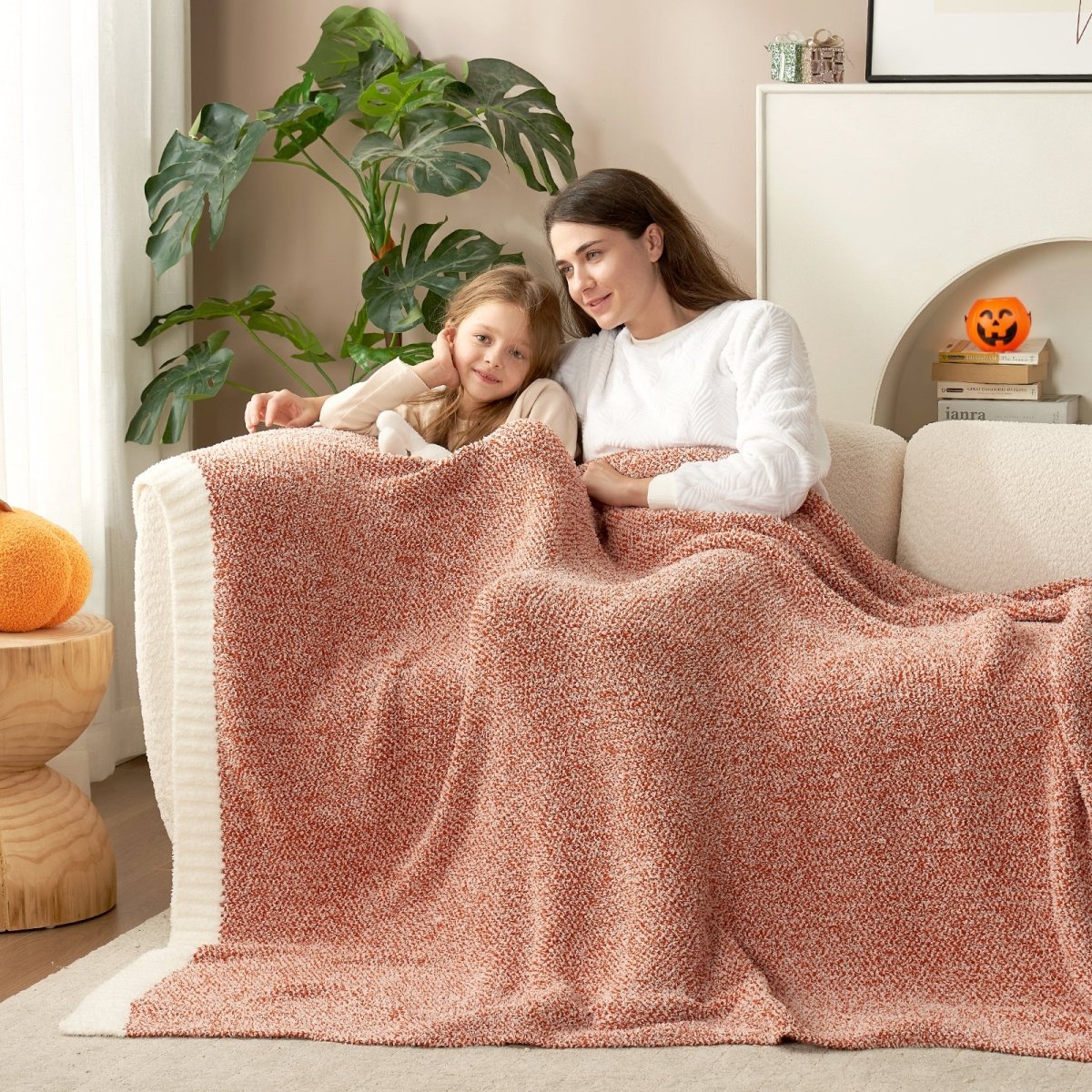Adult and child sharing a Heather Feather Yarn Throw Blanket in Orange, perfect for family comfort. #color_Orange
