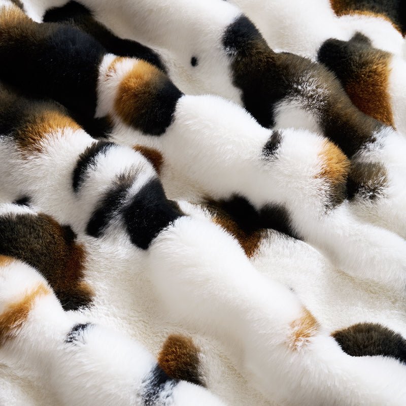 Close-up of a faux fur cow print blanket fabric. #Color_Cow