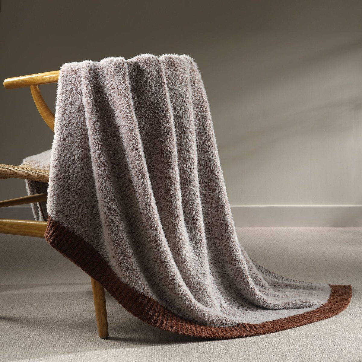 Faux Mink Feather Knit Throw Blanket in Brown draped over a chair, showcasing soft faux mink texture and warm knit design. #color_Brown