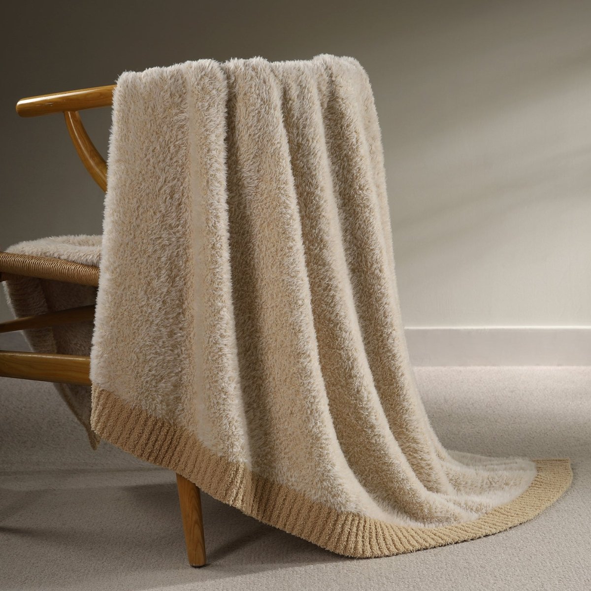 Faux Mink Feather Knit Throw Blanket in Beige draped over a chair, showcasing soft faux mink texture and elegant knit design. #color_Beige