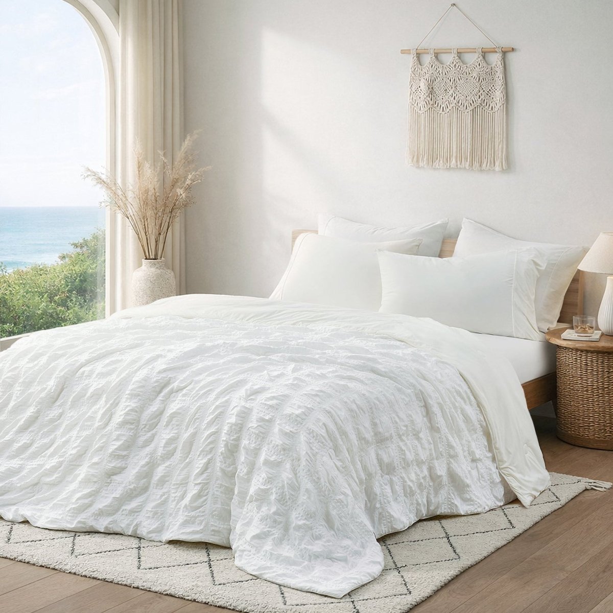 Cozy Bliss white seersucker cooling comforter in bright coastal bedroom, breathable lightweight bedding with textured fabric.#Color_Off White