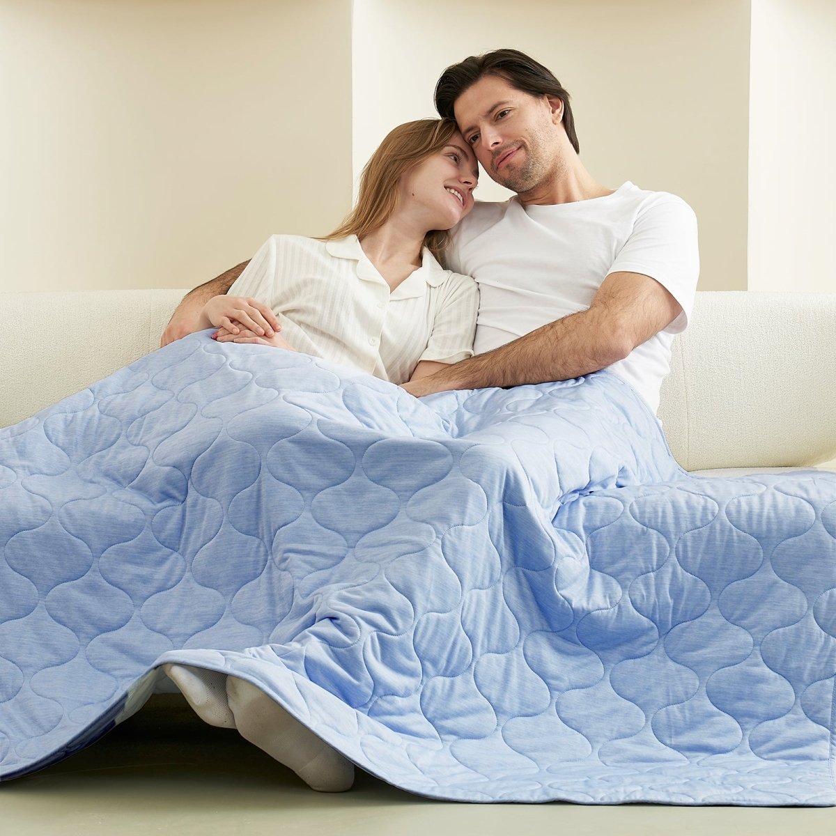 Couple relaxing under a cool blue cooling blanket on a sofa, cozy bedding #color_Cool Blue