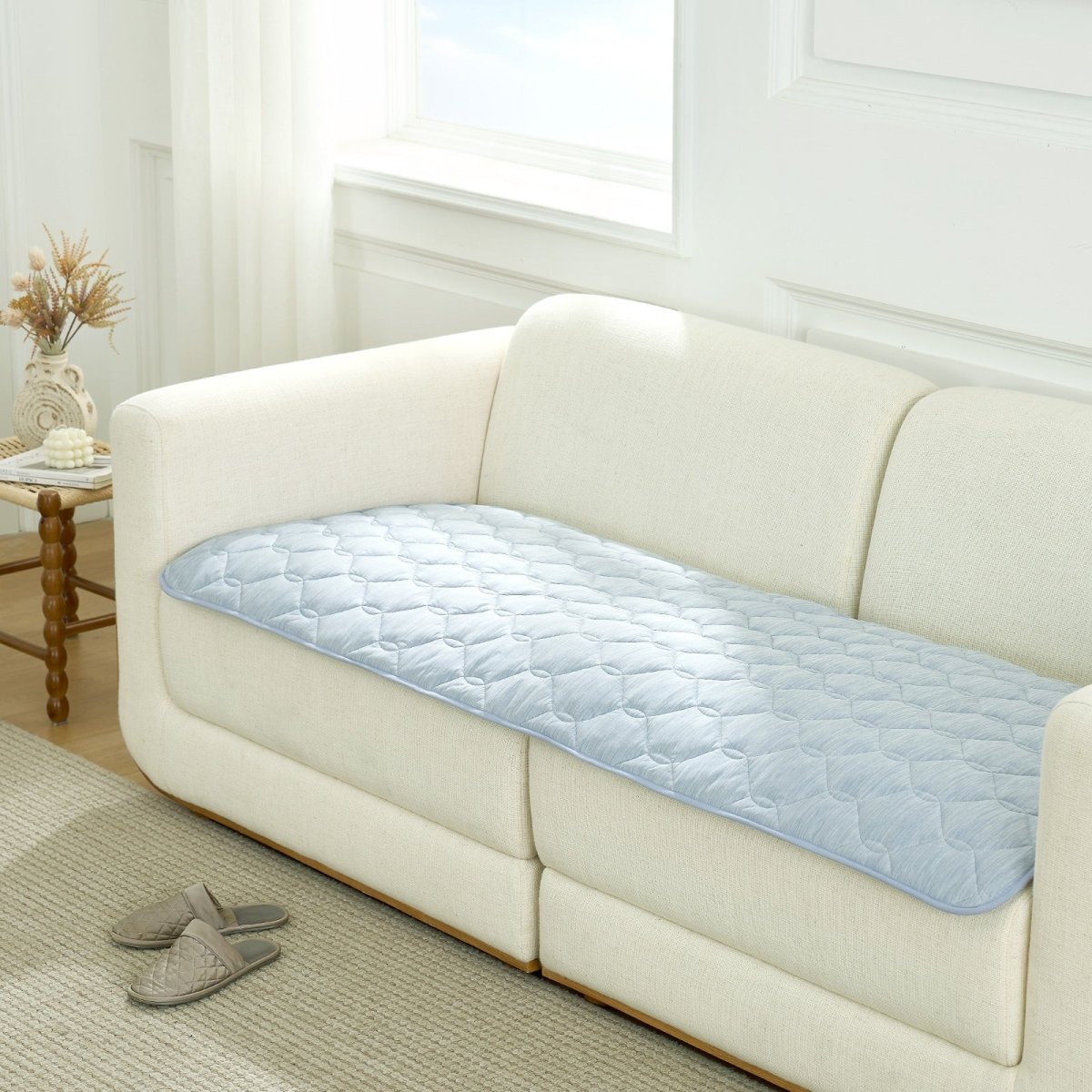 Blue couch cover on a white sofa in a living room setting.#Color_Cool Blue