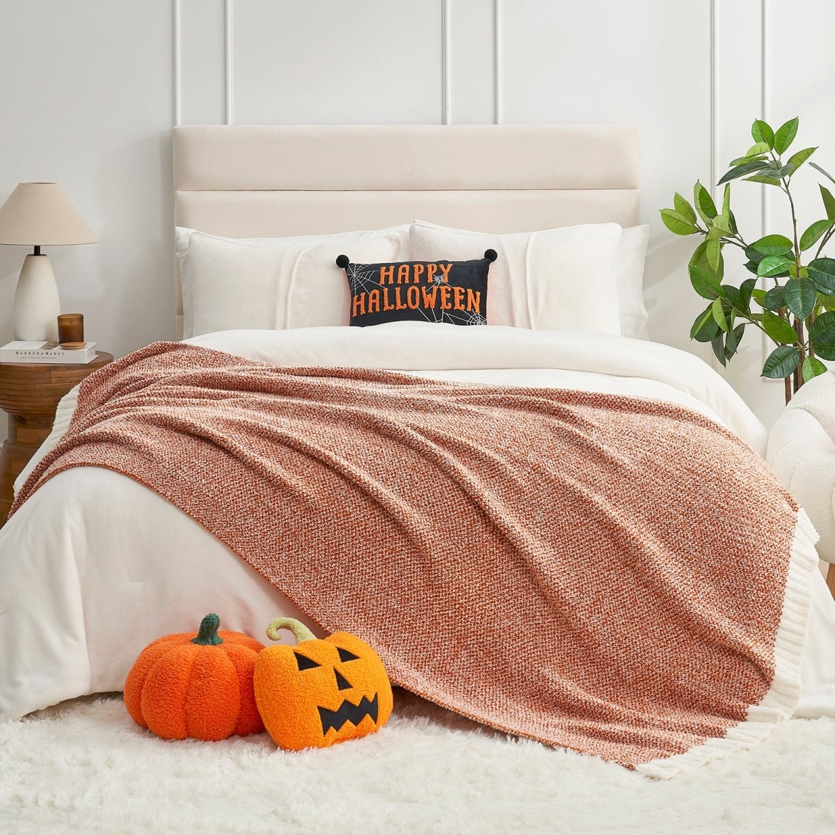 Heather Feather Yarn Throw Blanket in orange styled on a bed, enhancing bedroom decor with a soft, elegant and cozy layered look.  #Color_Orange