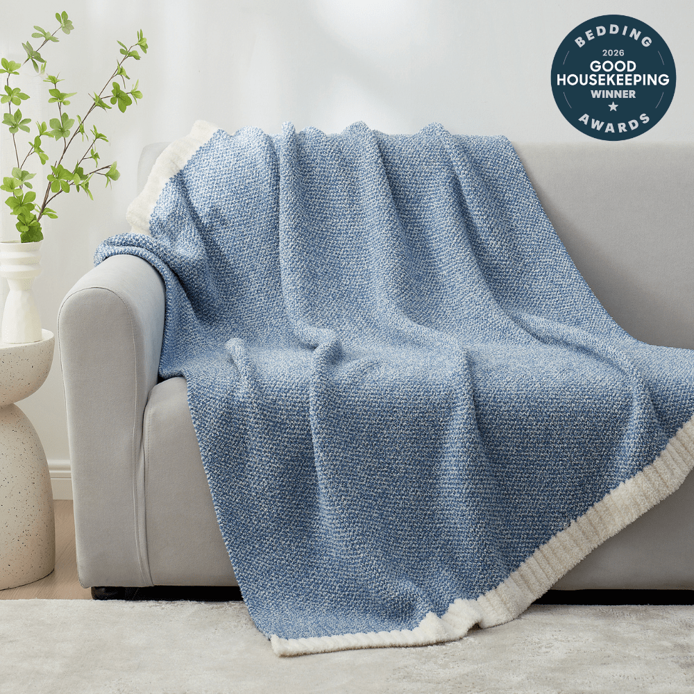 Heather Feather Yarn Throw Blanket in misty blue draped over a sofa, adding warmth, softness and a modern cozy touch to your living room. #Color_Misty Blue