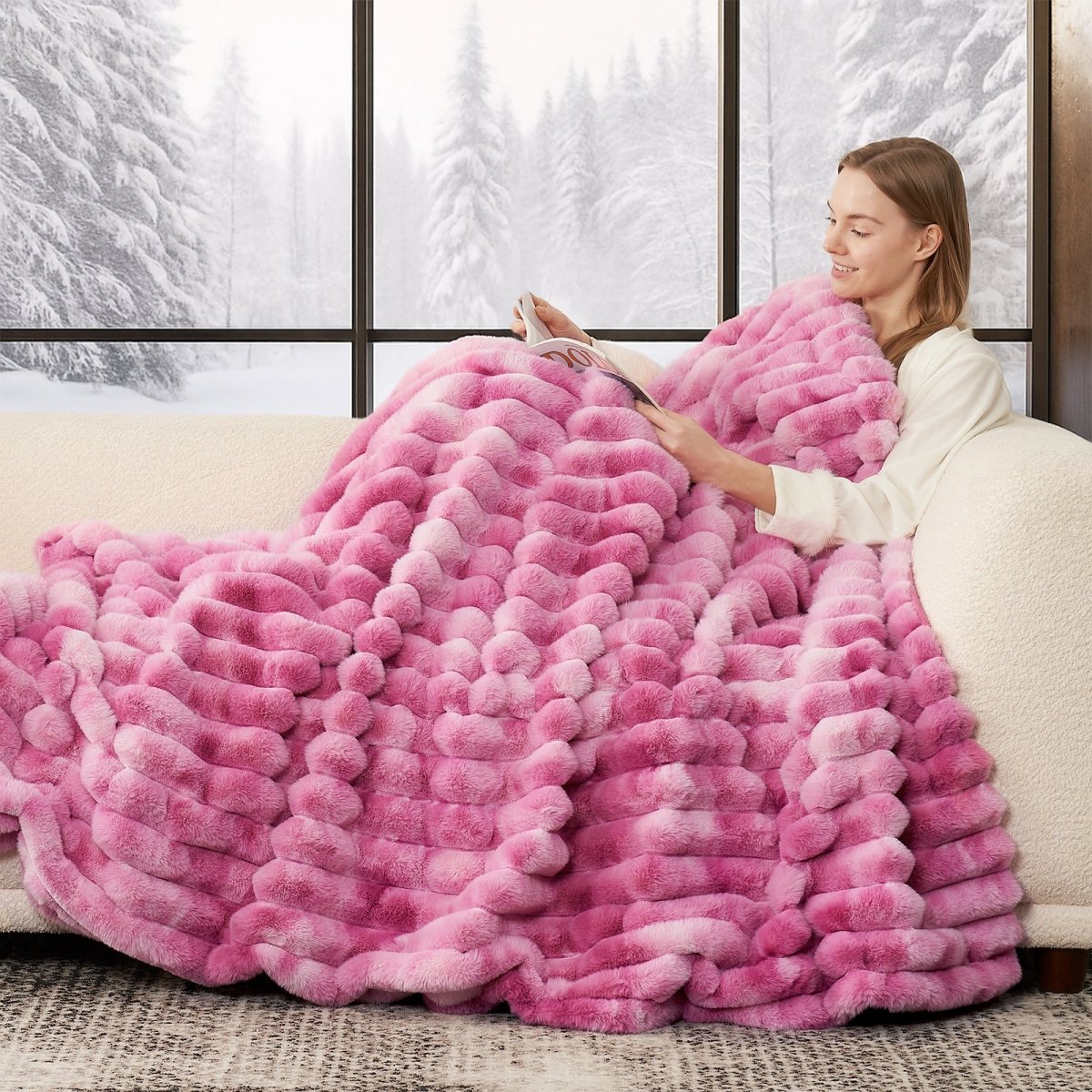 Woman sitting on a couch under a pink blanket with a snowy window background. #color_Tie-dye Pink