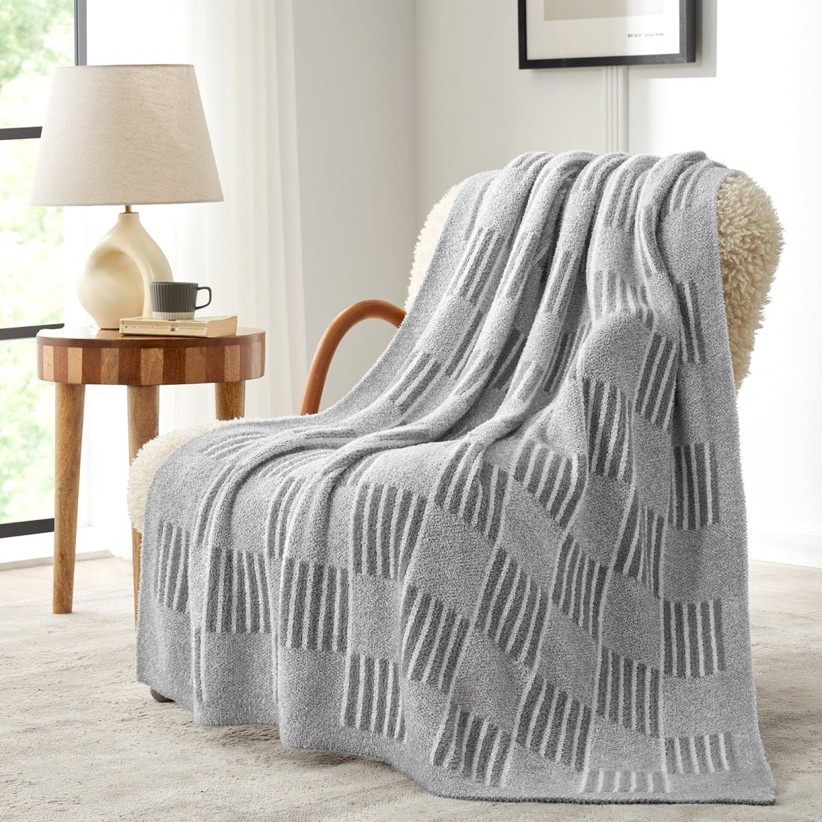 Reversible Heather Checkered Feather Yarn Throw Blanket in Grey draped over an armchair, showcasing its cozy texture and modern pattern. #color_Grey