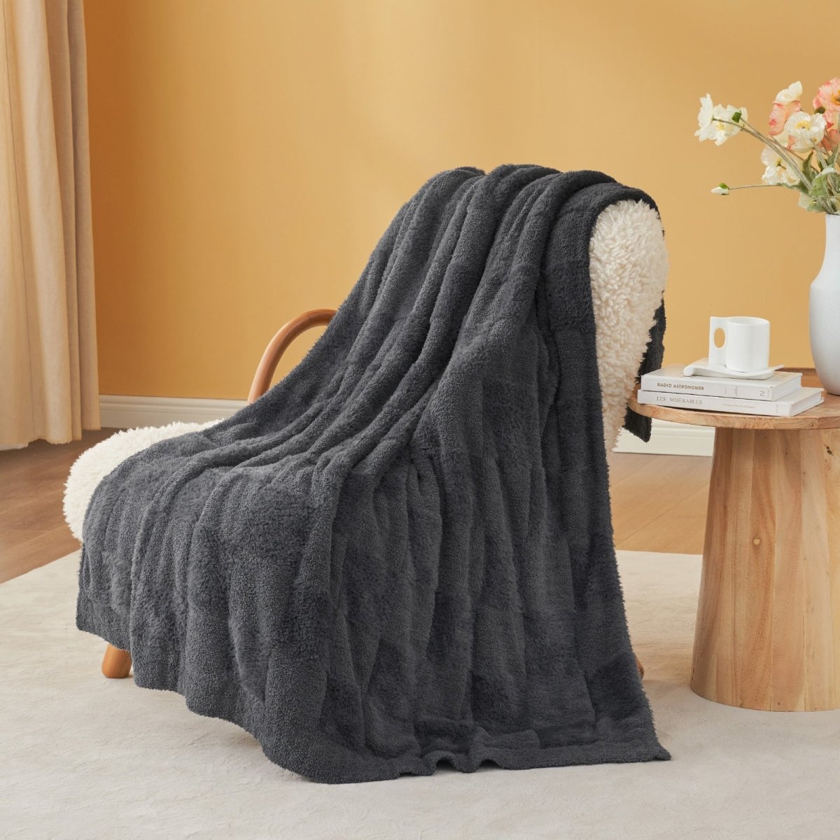 Checkered Faux Fur Feather Yarn Throw Blanket in Dark Grey draped over an armchair, adding a modern cozy feel. #color_Dark Grey