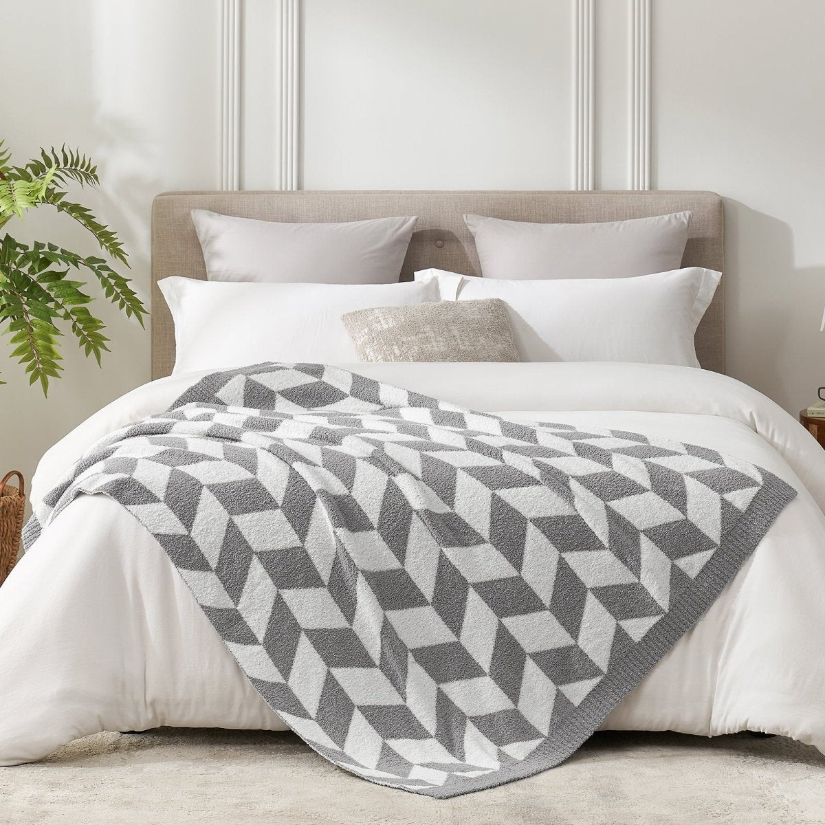 Chevron Feather Yarn Knit Throw Blanket in Grey styled on a bed, highlighting soft texture and modern chevron pattern in a bright bedroom setting. #color_Grey