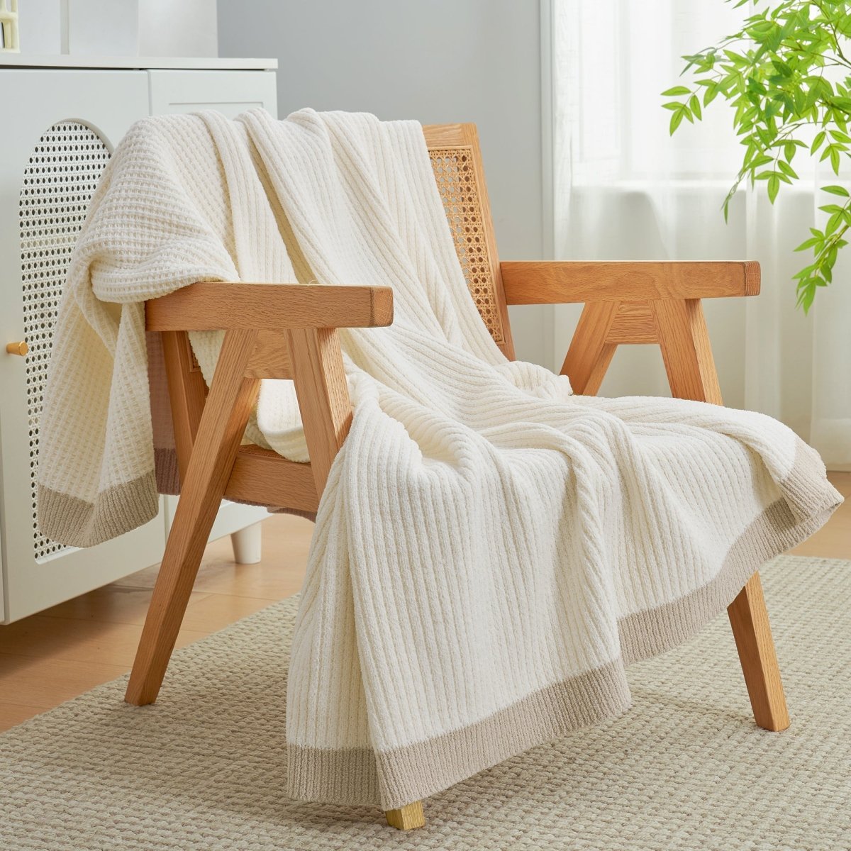 Chenille Waffle Knit Throw Blanket in Ivory draped over an armchair, creating a warm, inviting and stylish home atmosphere. #color_Ivory