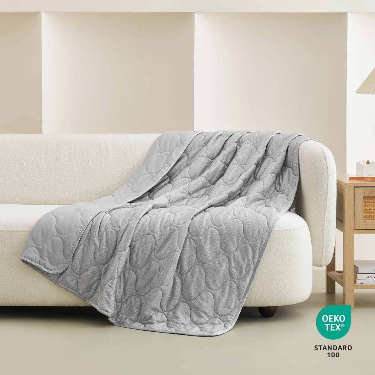 Light grey cooling blanket on a white sofa, cloud pattern, OEKO-TEX #color_Light Grey
