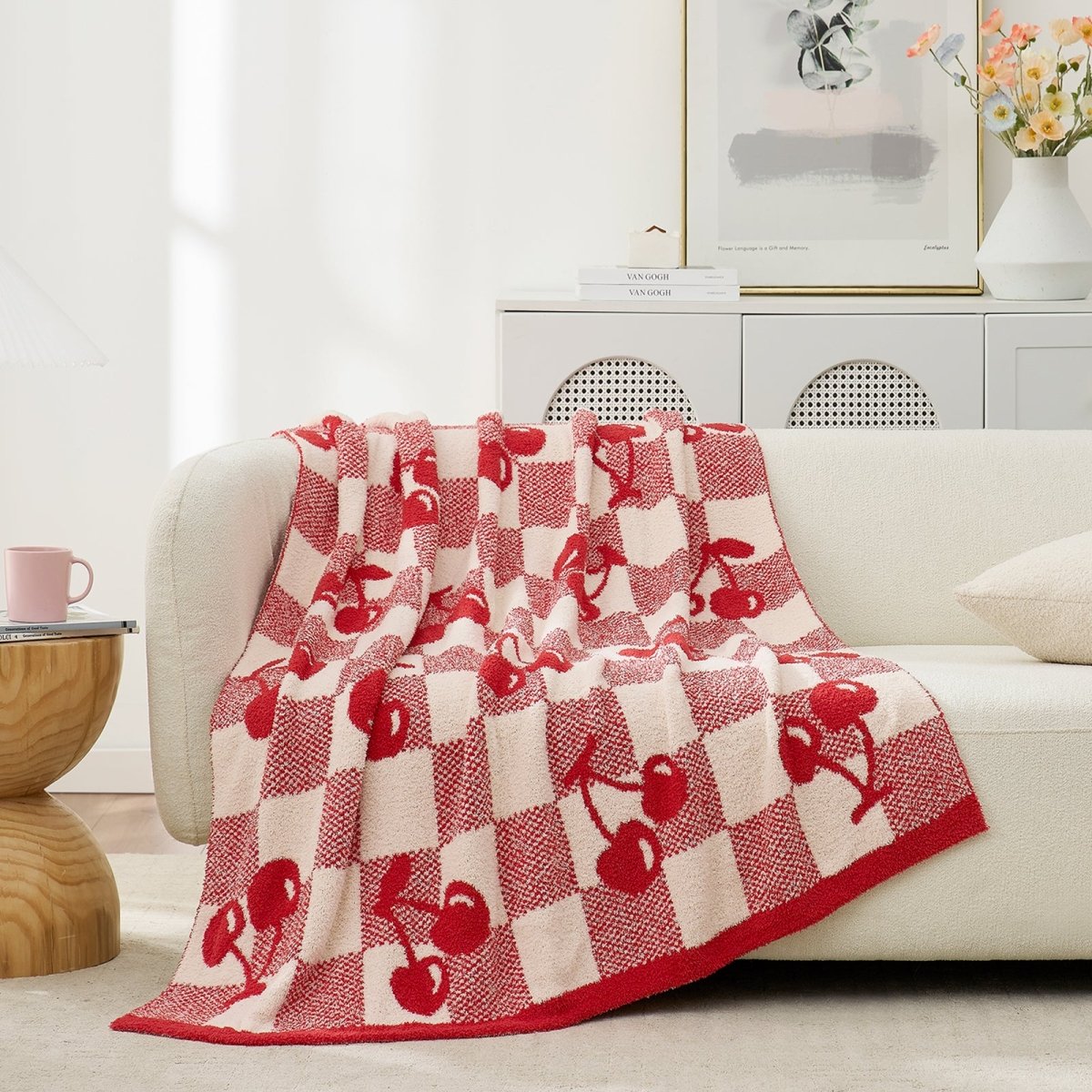 Reversible Checkered With Red Cherry Throw Blanket in Red Cherry draped over a sofa, showcasing cozy texture and playful cherry pattern design. #color_Red Cherry