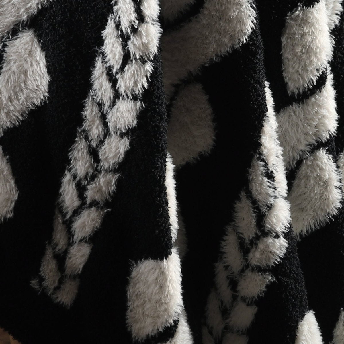 Close-up of cable knit pattern on Faux Mink Cable Knit Throw Blanket in Black highlighting soft faux mink fibers and textured design. #color_Black