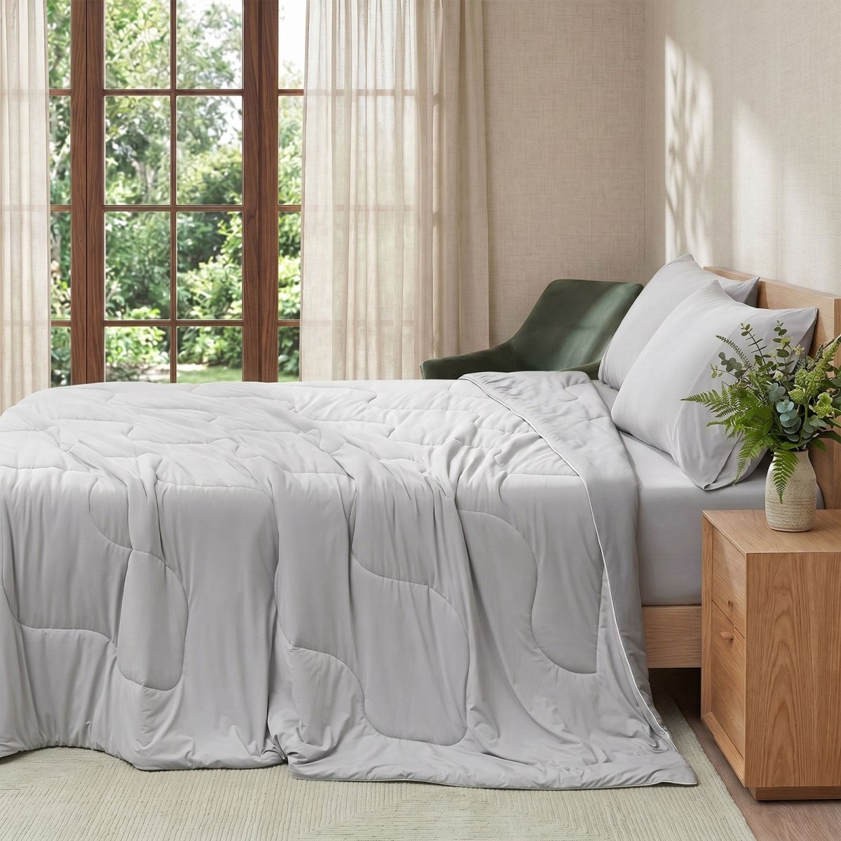 Cozy Bliss natural fiber cooling comforter on a bed in side view.#color_Light Grey