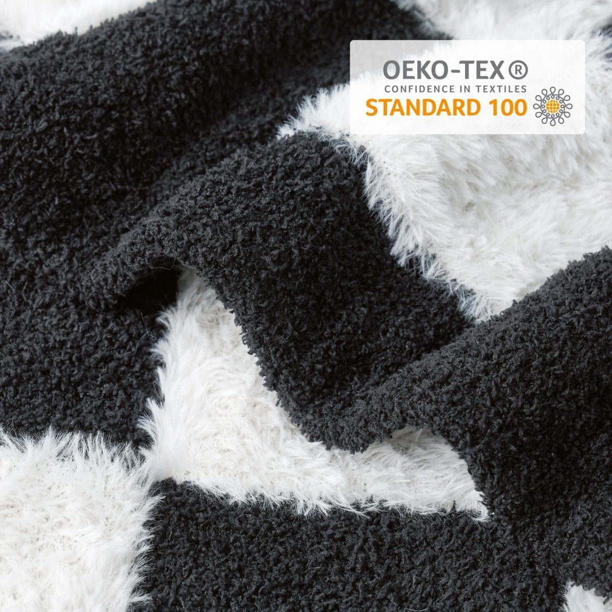 Close-up of Checkered Faux Fur Feather Yarn Throw Blanket in Black & White showcasing plush texture and OEKO-TEX STANDARD 100 certification. #color_Black & White