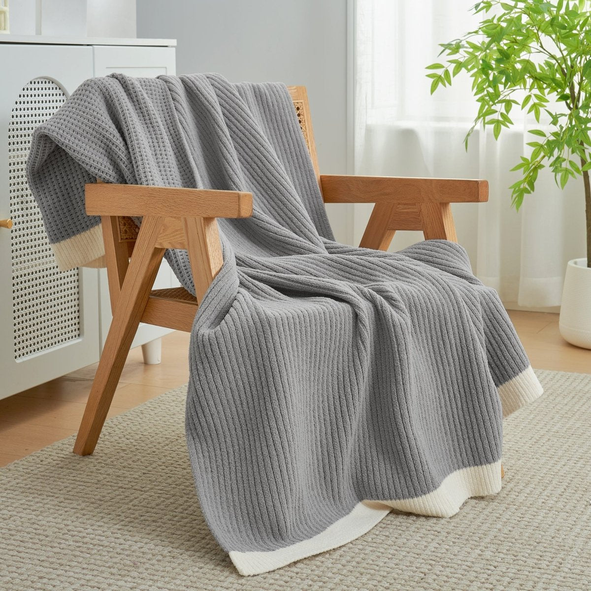 Chenille Waffle Knit Throw Blanket in Grey styled on an armchair, adding a modern and cozy layered look. #color_Grey
