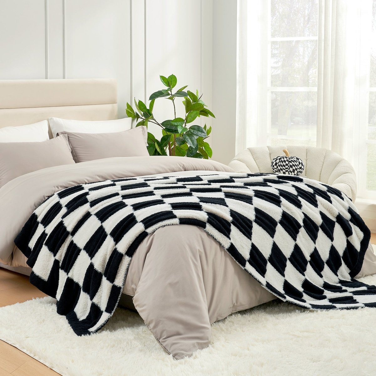 Checkered Faux Fur Feather Yarn Throw Blanket in Black & White styled on a bed, adding a cozy layered look. #color_Black & White