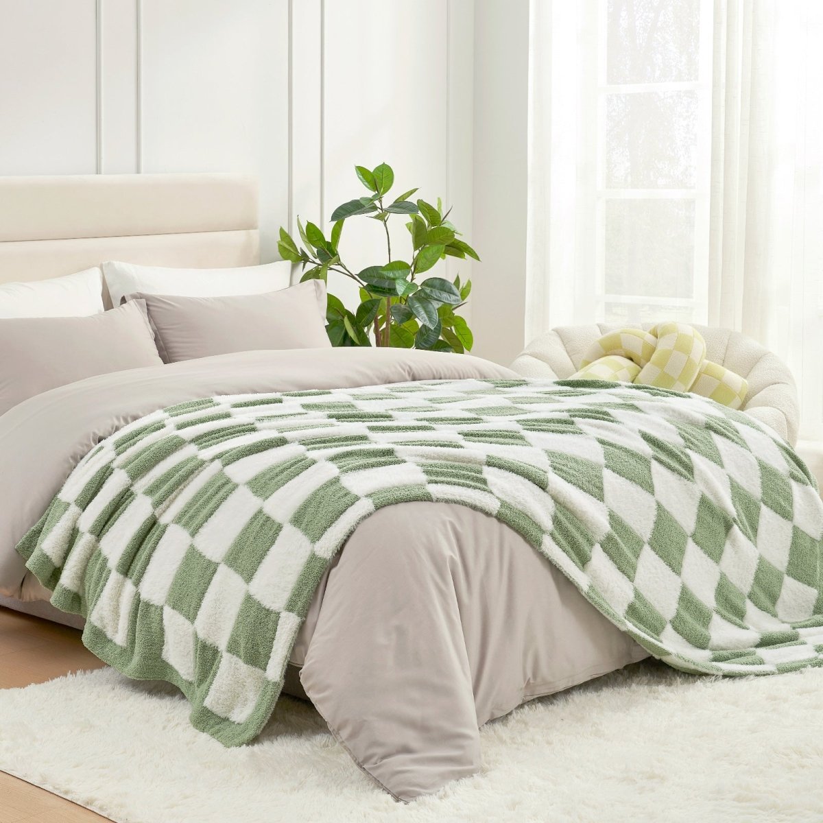 Checkered Faux Fur Feather Yarn Throw Blanket in Sage Green & White styled on a bed, creating a calming atmosphere. #color_Sage Green & White