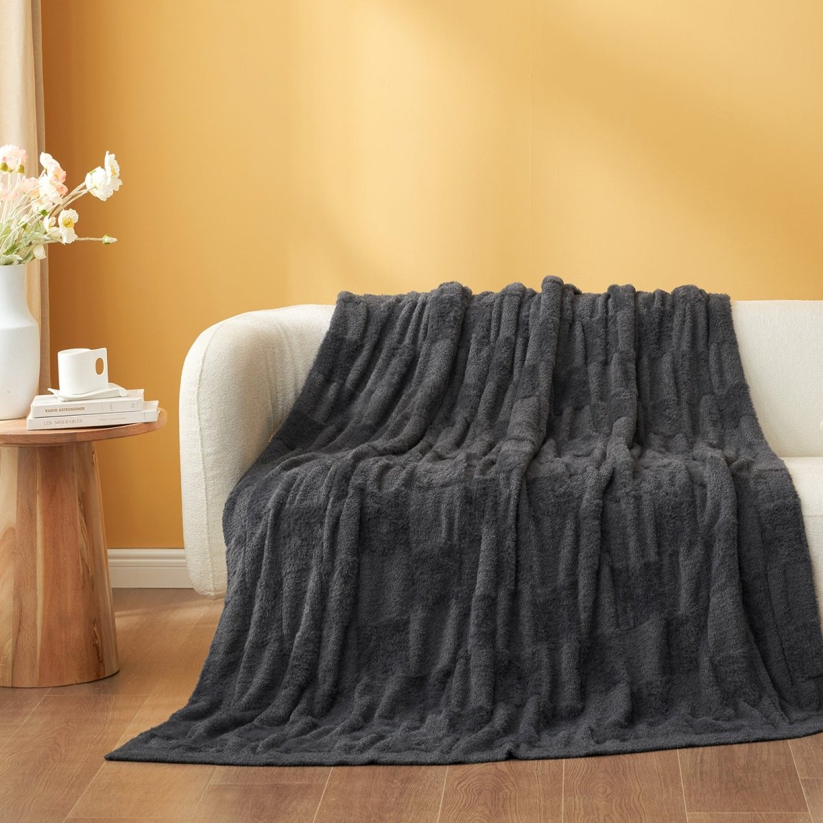 Checkered Faux Fur Feather Yarn Throw Blanket in Dark Grey draped over a sofa, highlighting its sleek look. #color_Dark Grey