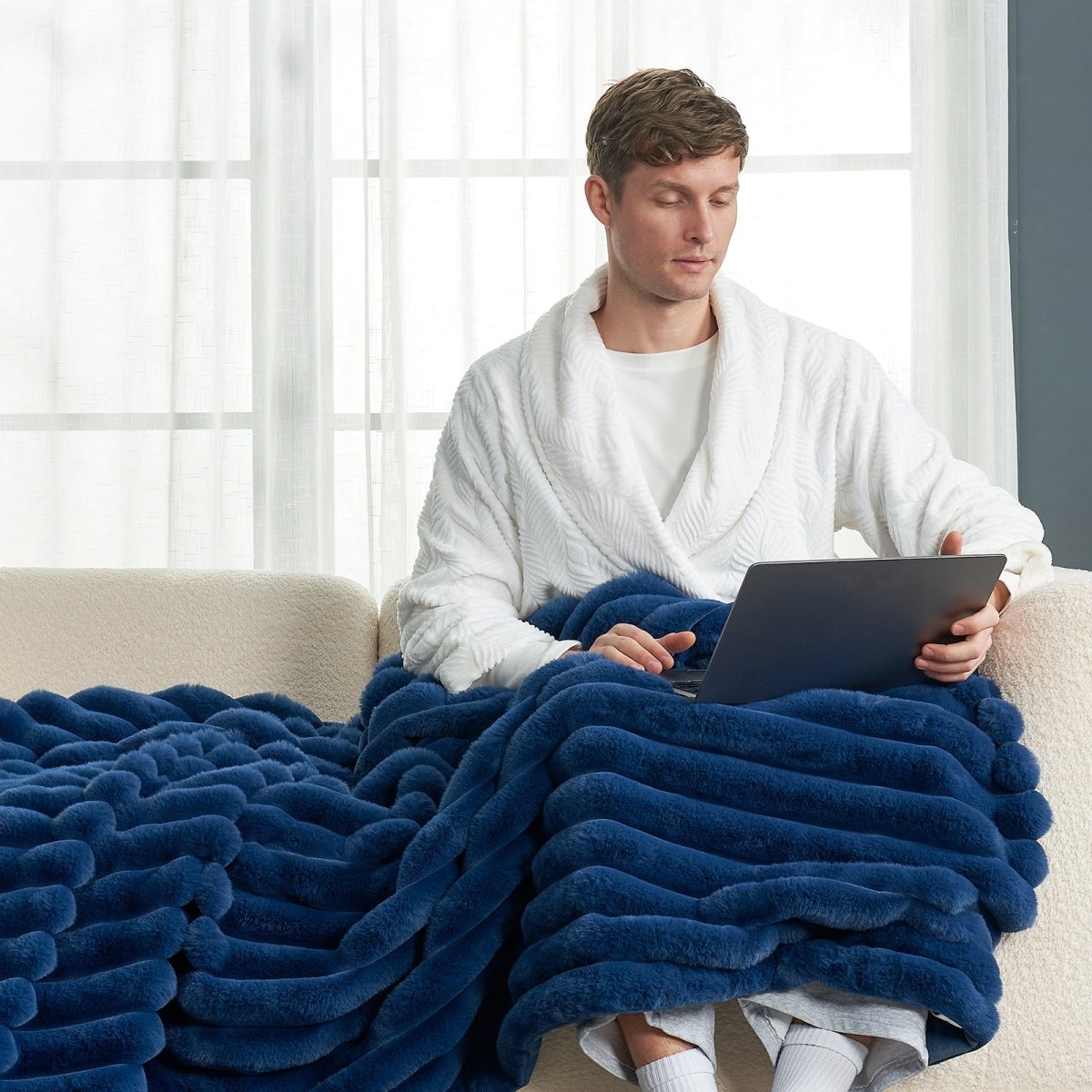 Man relaxing under Cozy Bliss navy blue striped faux fur blanket, for cozy warmth #color_Navy Blue