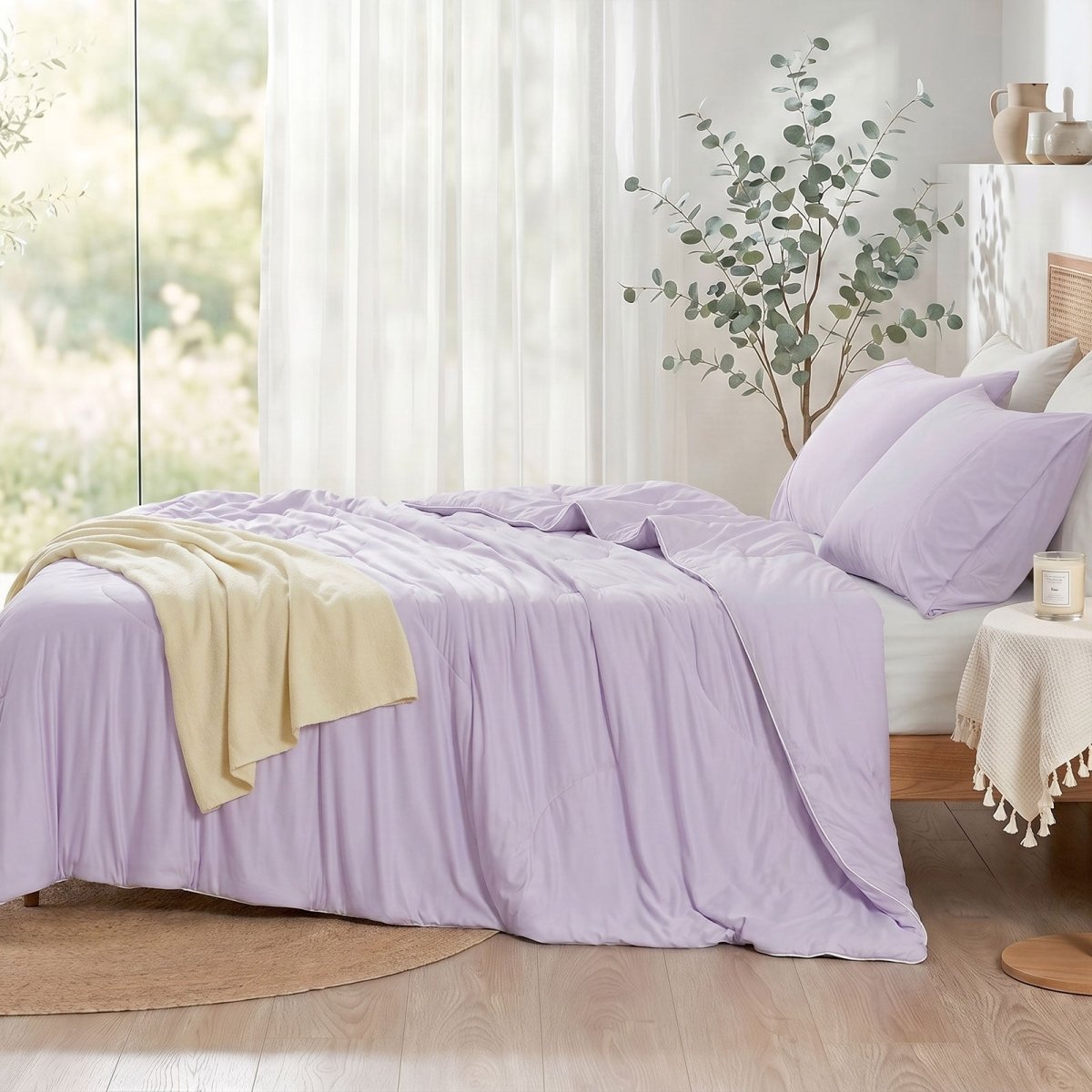 Cozy Bliss double-sided cooling comforter on a bed in a bright, sunlit bedroom with green plants, lightweight summer bedding for hot sleepers.#color_Purple