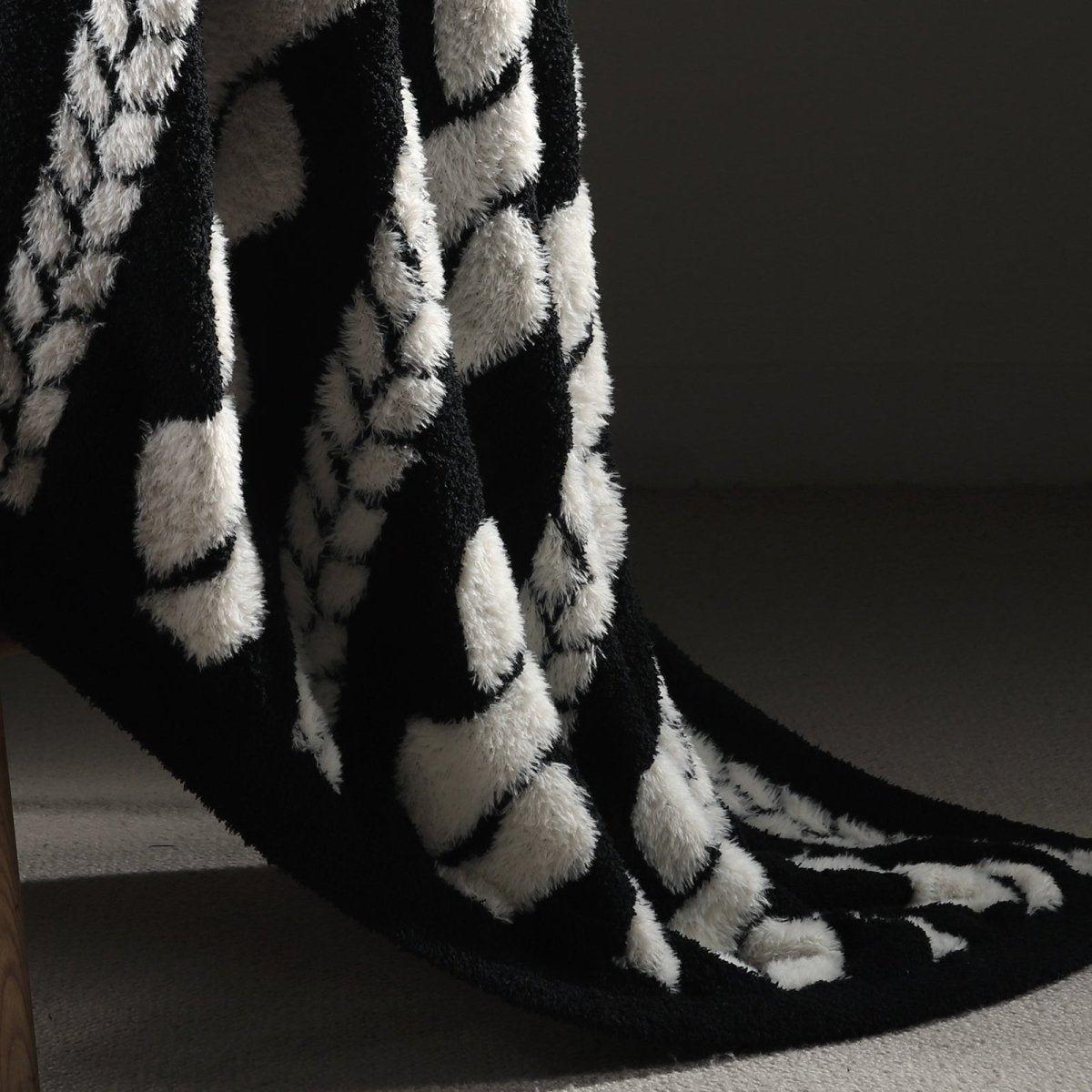 Close-up of cable knit pattern on Faux Mink Cable Knit Throw Blanket in Black highlighting soft faux mink fibers and textured design. #color_Black